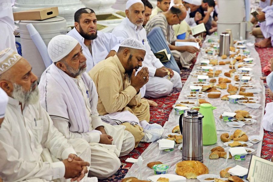 بالصور.. أهالي المدينة يتشاركون في إعداد موائد الإفطار في ساحات المسجد النبوي