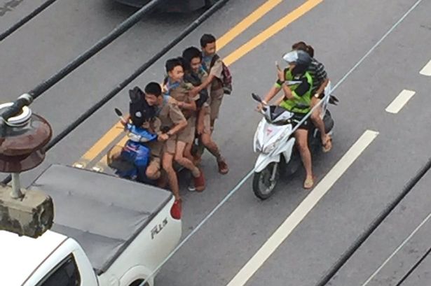 6 أطفال يركبون دراجة نارية واحدة إلى المدرسة
