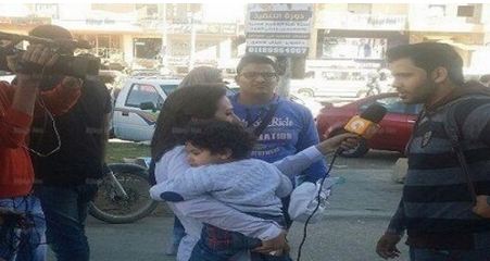 صورة مراسلة مصرية تحمل ابنها تثير الجدل