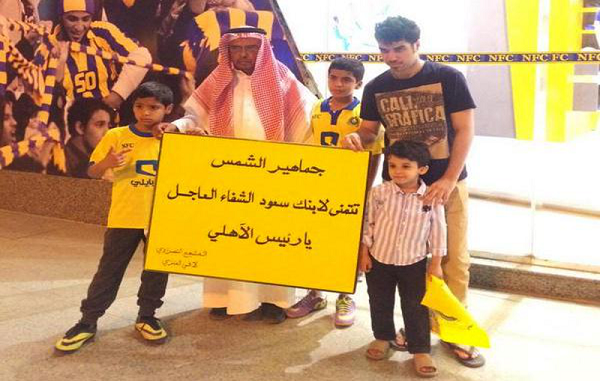 مشجع نصراوي يحمل لافتة كتب عليها دعوات لابن رئيس الأهلي