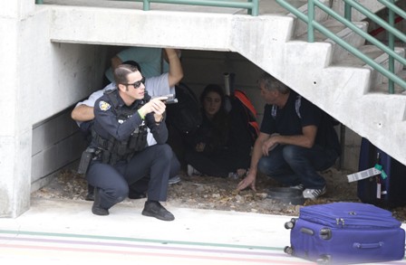 Law enforcement personnel shield civilians outside a garage area at Fort Lauderdaleâ€“Hollywood International Airport, Friday, Jan. 6, 2017, in Fort Lauderdale, Fla. A gunman opened fire in the baggage claim area at the airport Friday, killing several people and wounding others before being taken into custody in an attack that sent panicked passengers running out of the terminal and onto the tarmac, authorities said. (AP Photo/Wilfredo Lee)